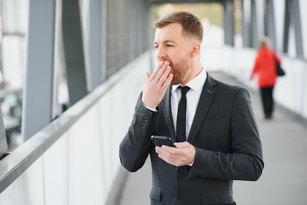 Homme d'affaires utilisant un smartphone dans un passage couvert