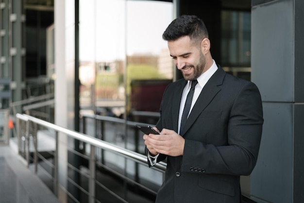 Homme d'affaires utilisant un smartphone dans la rue