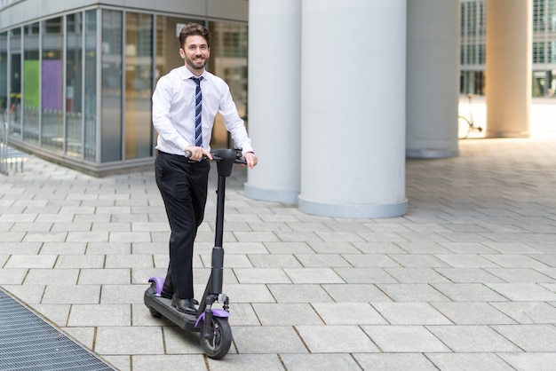 Homme d'affaires utilisant son scooter électrique