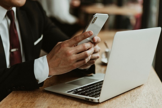 Homme d'affaires utilisant son téléphone portable dans un café