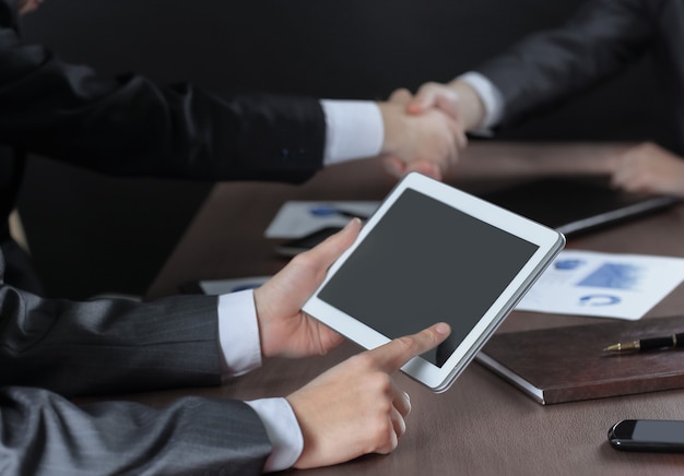 L'homme d'affaires utilise une tablette numérique lors d'un briefing au bureau