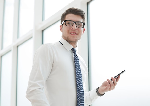 Homme d'affaires utilise le téléphone et sourit au bureau