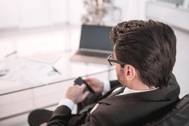 Homme d'affaires de vue arrière assis à son bureau