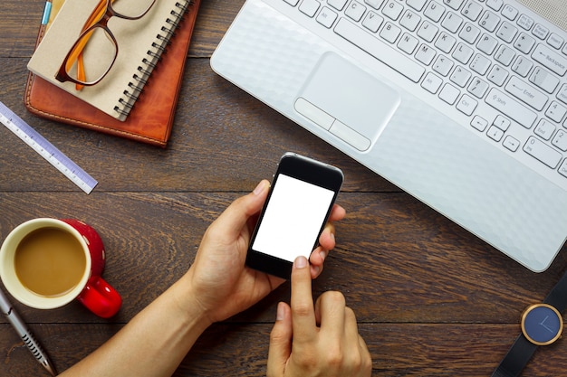 Homme d&#39;affaires vue de dessus à l&#39;aide de téléphone portable sur le bureau en bois.