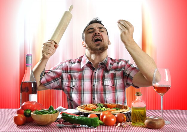 Homme affamé fou manger une pizza dans un restaurant