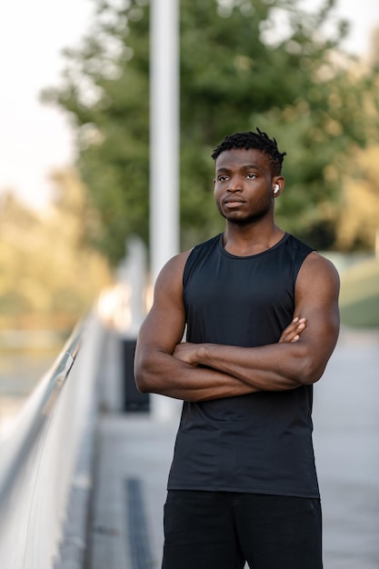 Un homme africain confiant en vêtements de sport faisant une pause pendant l'entraînement en plein air