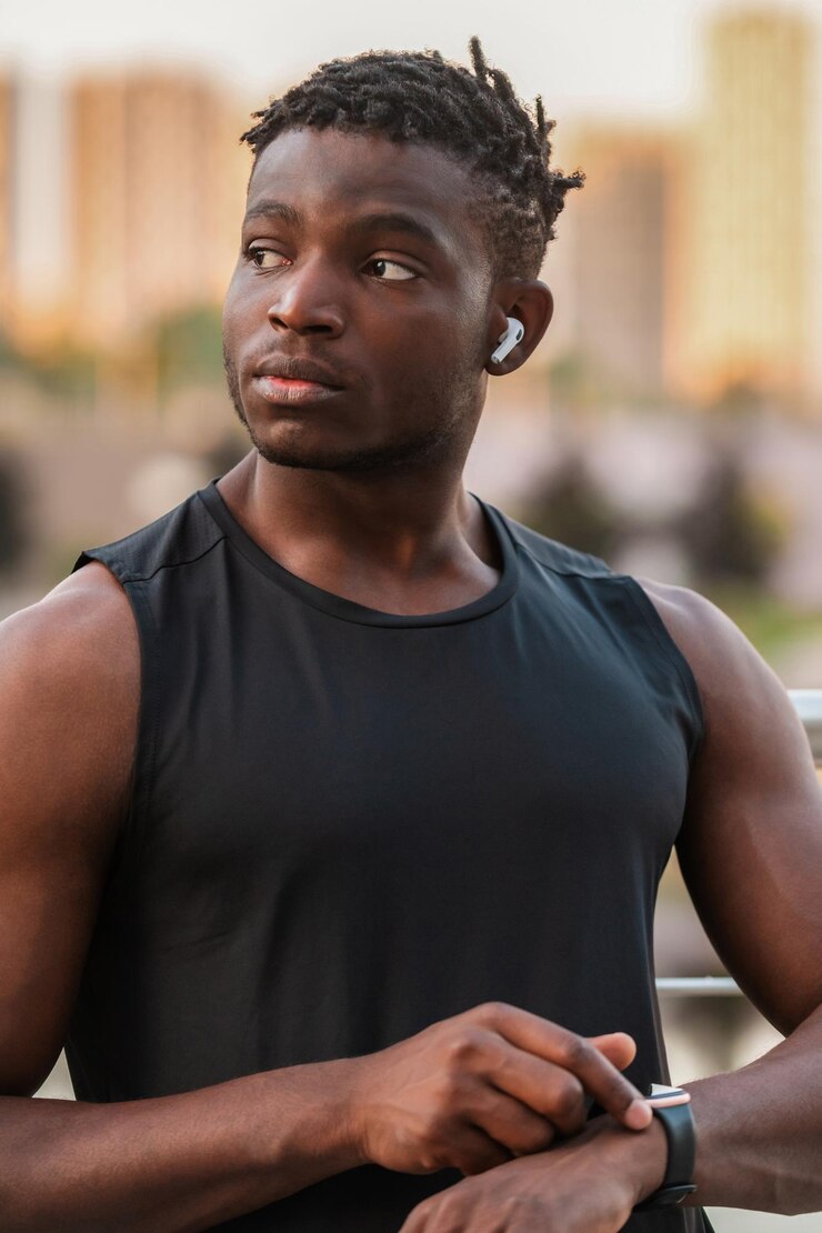 Photo un homme africain confiant en vêtements de sport utilisant une montre intelligente pendant son entraînement sportif à l'extérieur