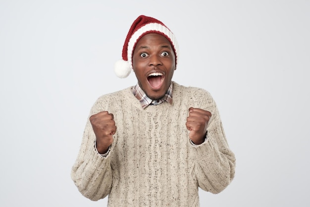 Homme africain drôle de Noël au chapeau rouge sur fond gris