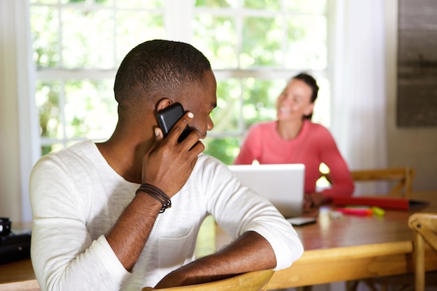 Homme africain faisant un appel téléphonique et regardant la femme