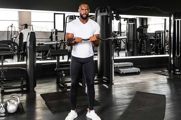 Homme africain en forme et musclé soulevant des poids lourds à la salle de sport