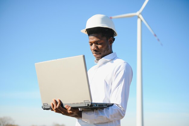 Homme africain d'ingénieur se tenant avec l'éolienne