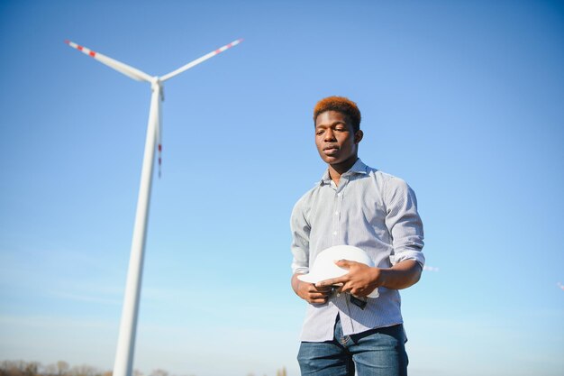 Homme africain d'ingénieur se tenant avec l'éolienne