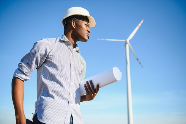 Homme africain d'ingénieur se tenant avec l'éolienne