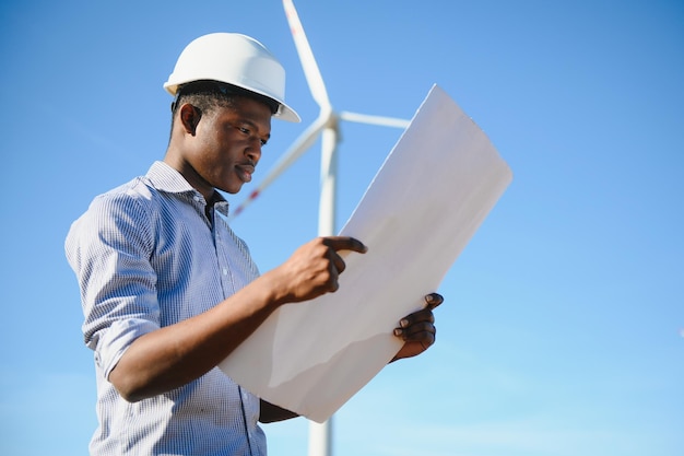 Homme africain d'ingénieur se tenant avec l'éolienne