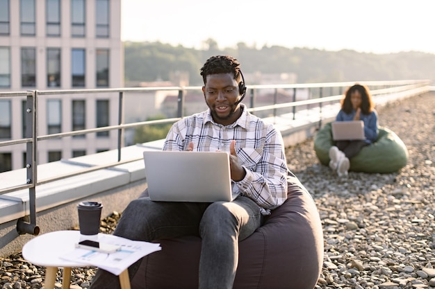 Un homme africain portant un casque tient une conférence en ligne sur un ordinateur portable