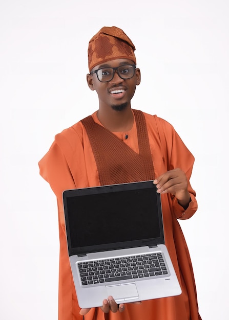 Homme africain portant une tenue traditionnelle indigène nigériane Yoruba agbada tenant un ordinateur portable portant des lunettes