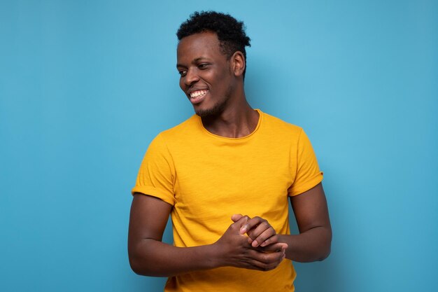 Homme africain souriant regardant de côté Portrait d'un homme noir confiant sur le mur bleu