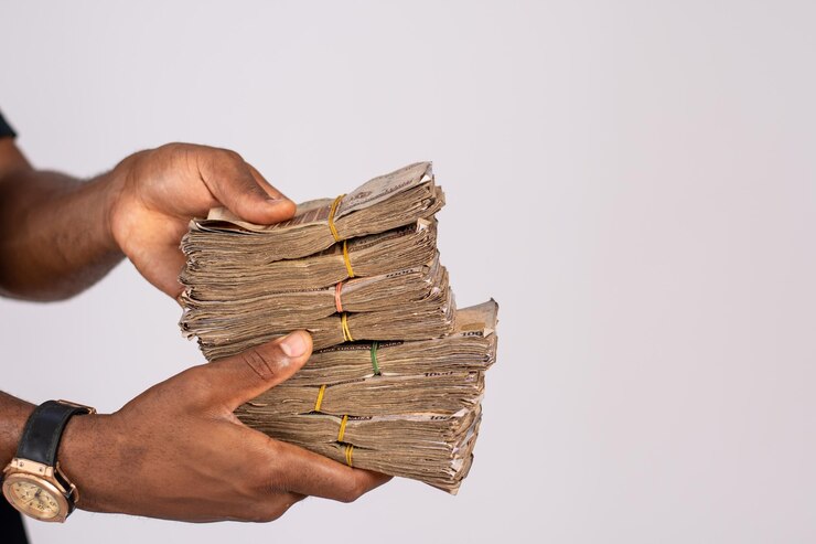 un homme africain tenant beaucoup d'argent