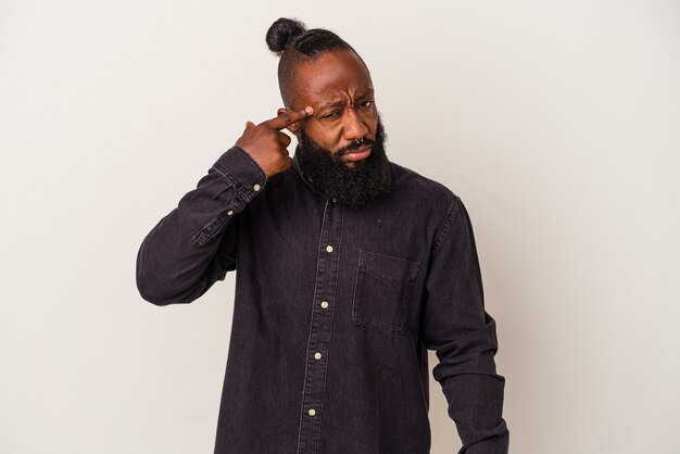 Photo homme afro-américain avec barbe isolé sur un mur rose pointant le temple avec le doigt, pensant, concentré sur une tâche.