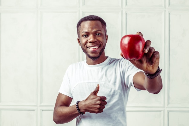 Homme afro-américain en bonne santé, tenant une pomme