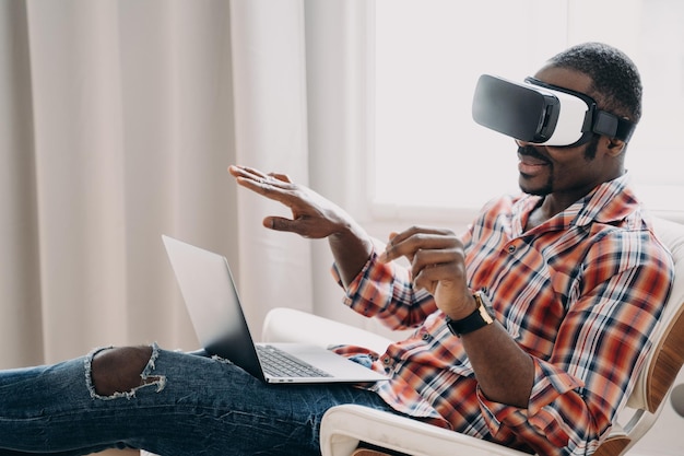 Homme afro-américain dans des lunettes de réalité virtuelle voir achat en ligne sur ordinateur portable Tech ecommerce