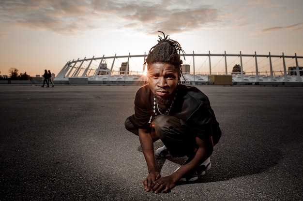 Homme afro-américain avec des dreadlocks assis sur le sol