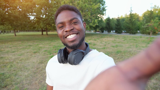 Un homme afro-américain enregistre une vidéo sur un smartphone en souriant