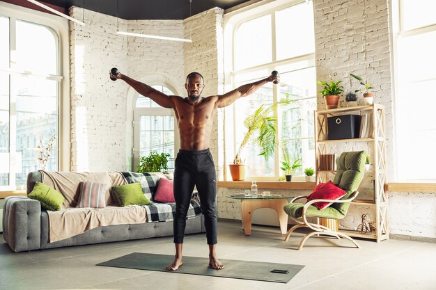 Photo homme afro-américain enseignant à domicile des cours en ligne de mode de vie sportif aérobie de remise en forme