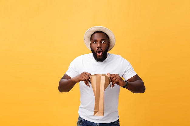 Un homme afro-américain est surpris d'ouvrir un sac en papier