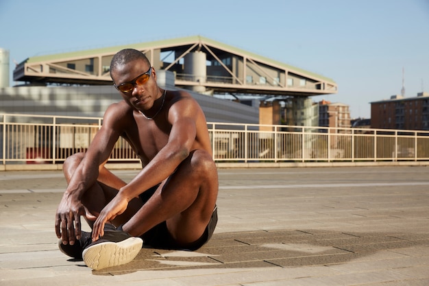 Homme afro-américain faisant des étirements en milieu urbain