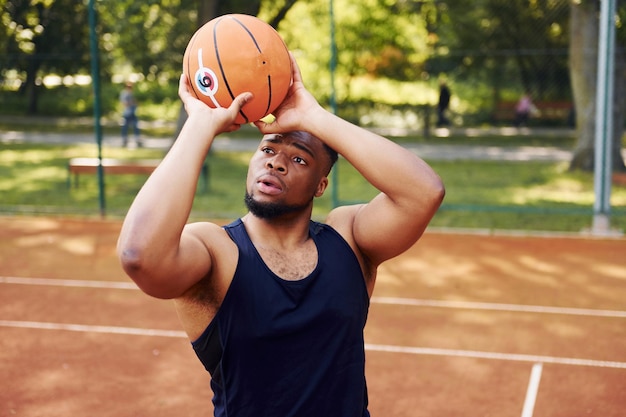 Un homme afro-américain joue au basket sur le terrain à l'extérieur