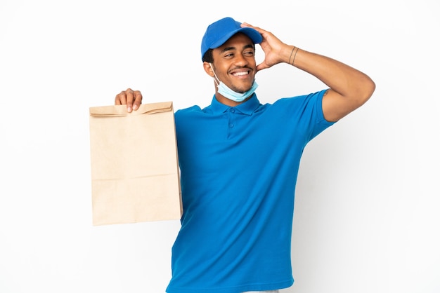 Homme afro-américain prenant un sac de nourriture à emporter isolé sur fond blanc souriant beaucoup