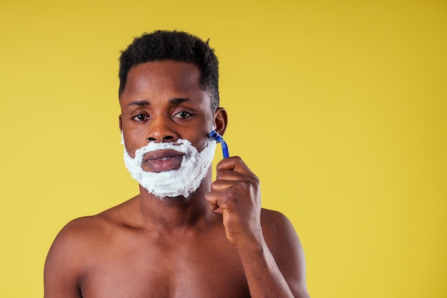 Homme afro-américain avec rasoir et mousse à raser sur son visage