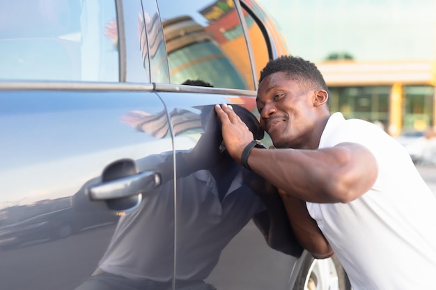 Un homme afro-américain souriant et heureux près de l'industrie automobile