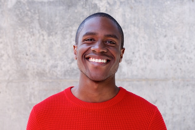 homme afro-américain souriant en pull rouge