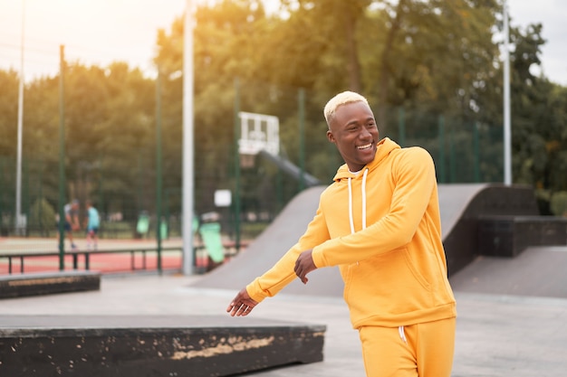 Homme afro-américain en sweat à capuche jaune à l'extérieur