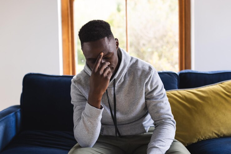Photo un homme afro-américain triste assis sur le canapé en train de faire un appel vidéo à la maison.
