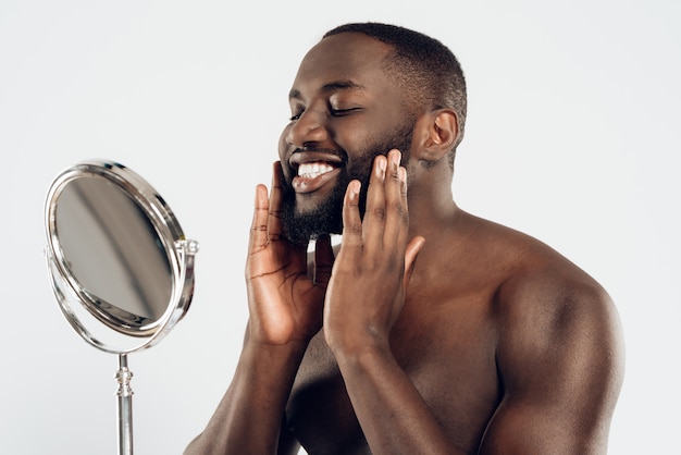 L&#39;homme afro-américain utilise une lotion hydratante.