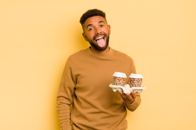 Homme afro noir avec une attitude joyeuse et rebelle plaisantant et tirant la langue à emporter concept de café