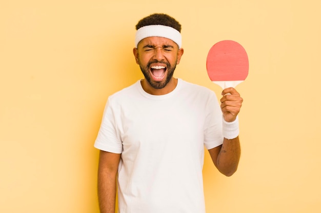 Homme afro noir criant agressivement à la recherche d'un concept de ping-pong très en colère