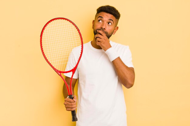 Homme afro noir pensant se sentir douteux et confus concept de tennis