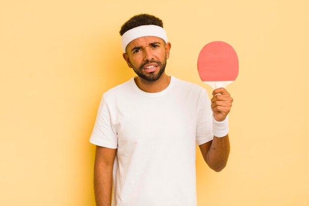 Homme afro noir se sentant perplexe et confus concept de ping-pong