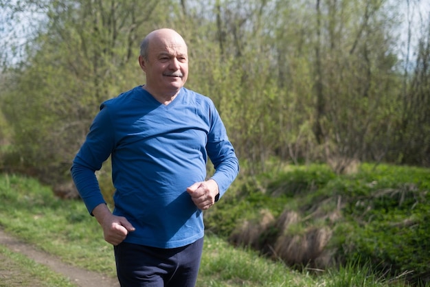 Un homme âgé actif fait du jogging dans le parc Mode de vie sain à la retraite