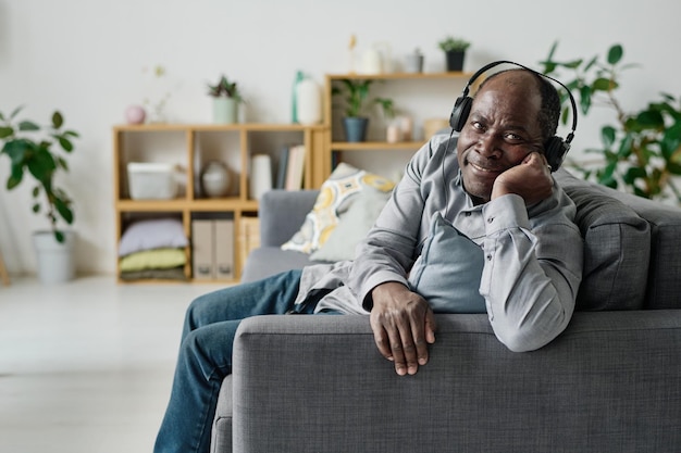 Homme âgé appréciant la musique à la maison