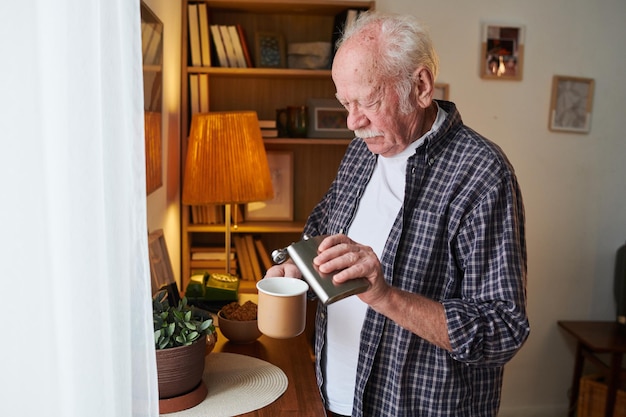 Homme âgé appréciant son thé à la maison