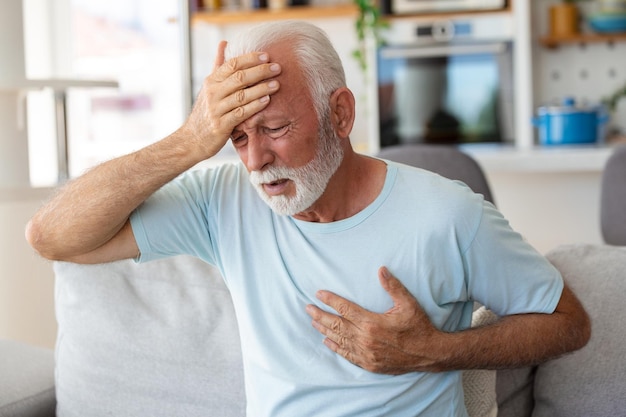 Un homme âgé appuie la main sur la poitrine a une crise cardiaque souffre d'une douleur insupportable