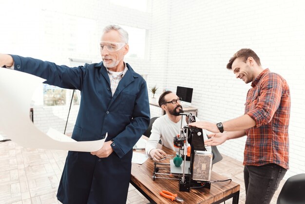 Un homme âgé au premier plan étudie un plan.