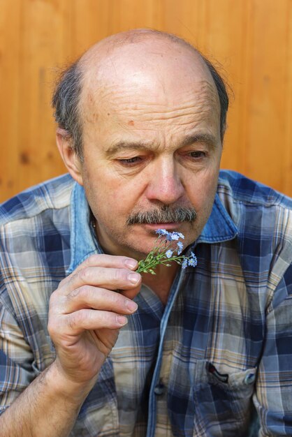 Homme âgé avec un bouquet d'oubli la tristesse du passé Tristes souvenirs d'amour