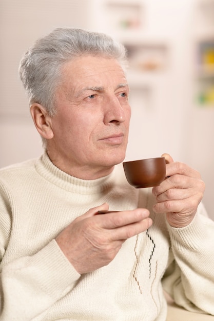 Homme âgé buvant une tasse de café, gros plan