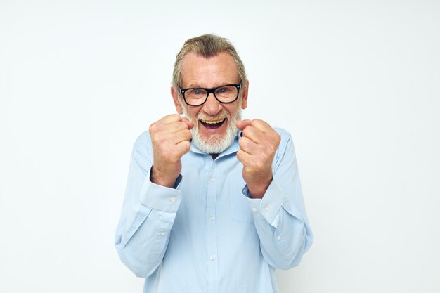 Homme âgé en chemise et lunettes posant des émotions fond isolé